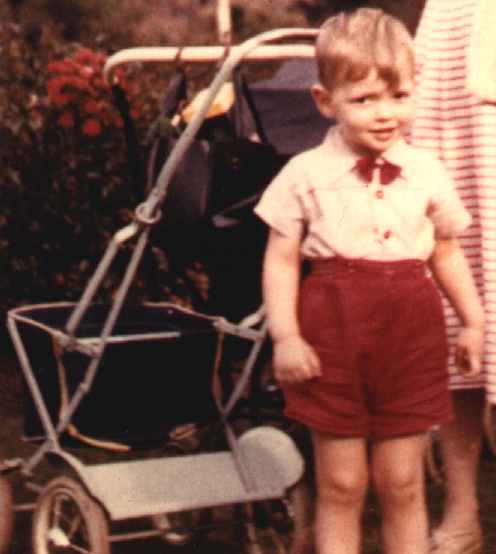 Baby Nelson standing by his pram in a London park